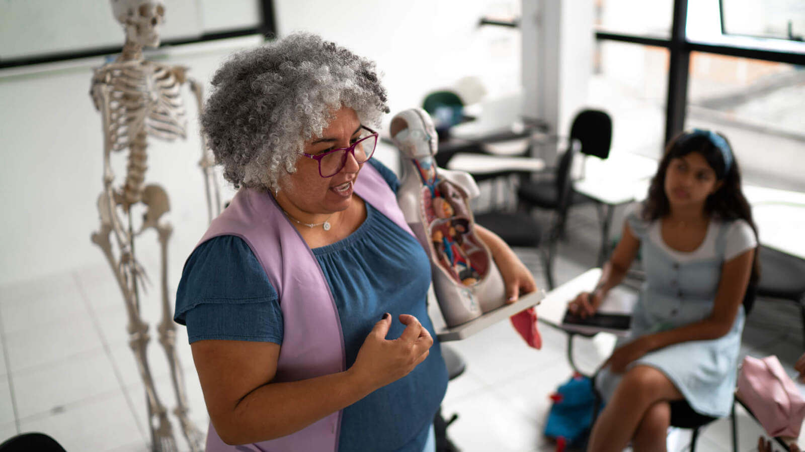 Professor holding an anatomical model, addressing students