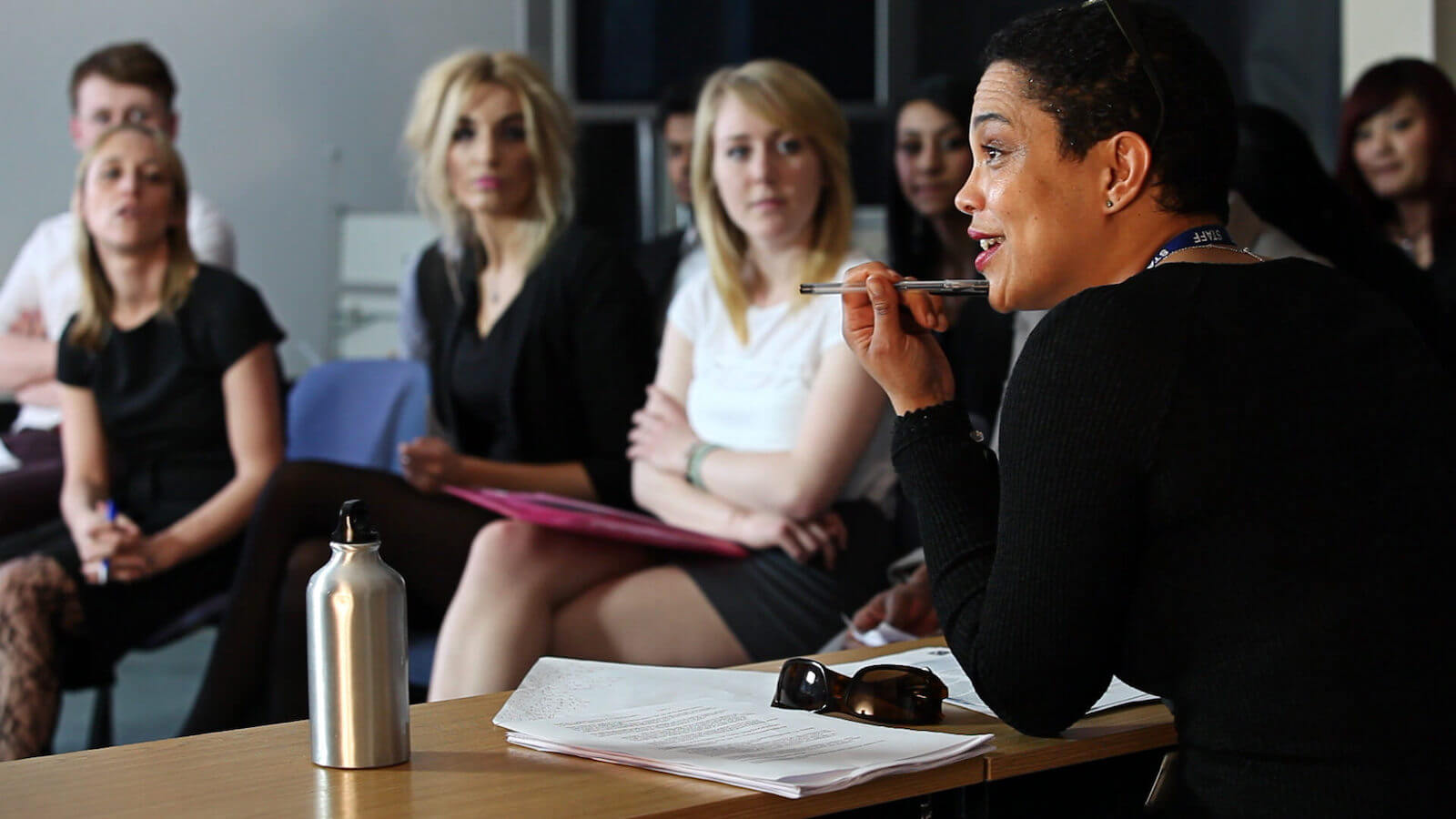 Seated professor addressing students